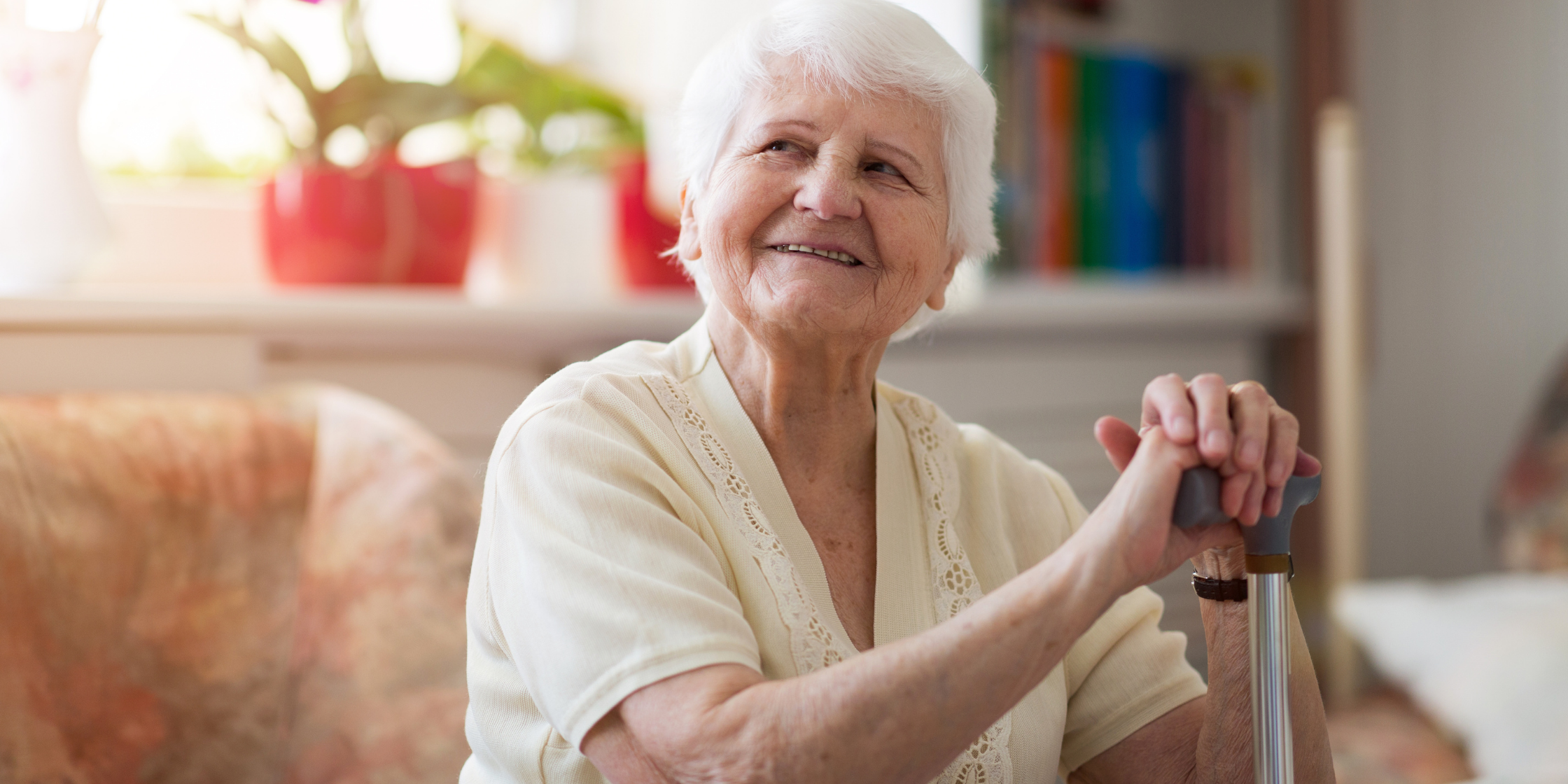 elderly woman smiling at camera while sitting in her living room